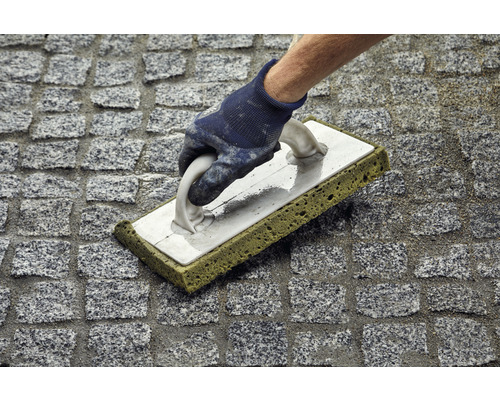 Voegreiniging van straatstenen met voegrubber