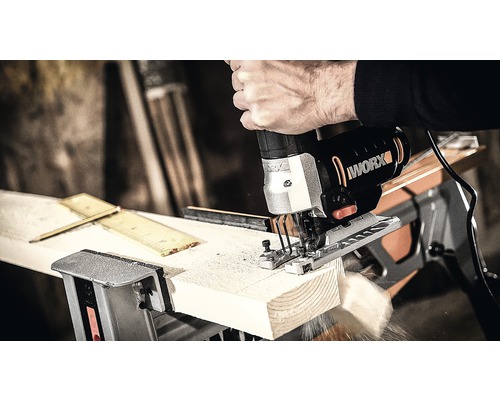 Een decoupeerzaag van het merk Worx zaagt een werkstuk.