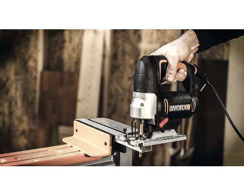 Hand houdt decoupeerzaag vast bij het zagen van hout