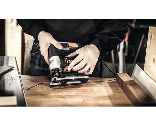 Een decoupeerzaag in gebruik op een werkbank.