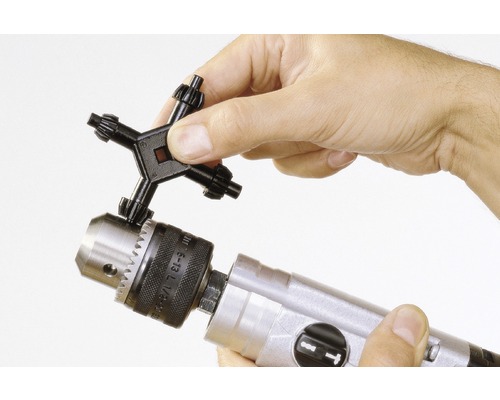 Een boorkopsleutel wordt in een boorkop gestoken.