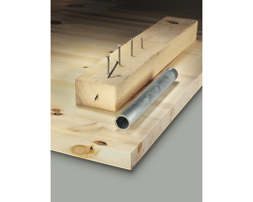 Houten plank met spijkers in een stuk hout en een buis