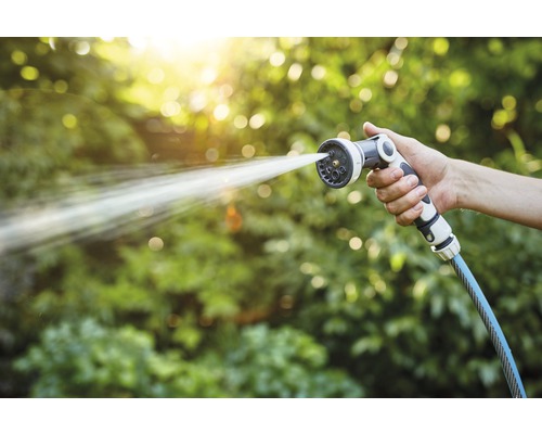 Tuinslang met sproeikop in gebruik