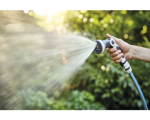 Hand houdt tuinslang vast met sproeikop