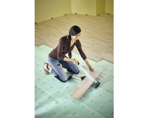 Vrouw snijdt laminaat met laminaatsnijder op isolerende onderlaag in de ruimte