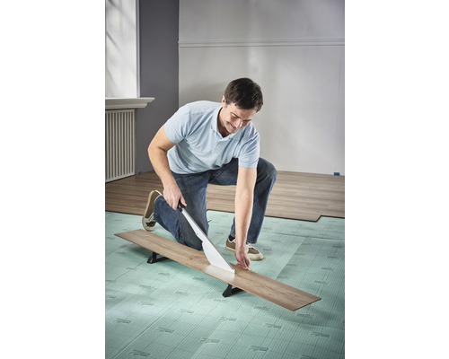 Man snijdt laminaat met laminaatsnijder op geluiddempende ondervloer