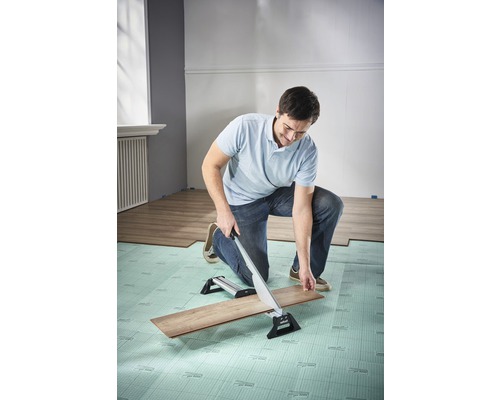 Man snijdt laminaat met een laminaatsnijder