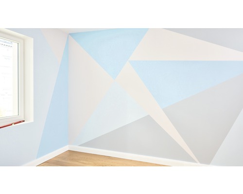 Wanddecoratie met geometrische vormen en verschillende kleurnuances in een interieur.