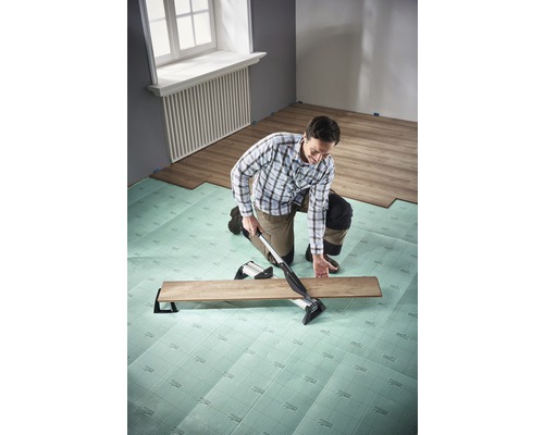 Man legt laminaat met laminaatsnijder op geluidsreducerende ondervloer