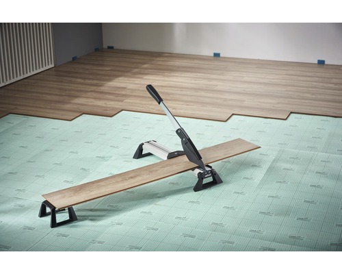 Laminaatsnijder bij het snijden van laminaat op een isolatiemat