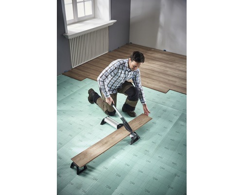 Man snijdt laminaat met laminaatsnijder op contactgeluidisolatie