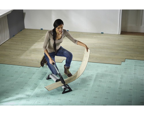 Vrouw snijdt laminaat met een laminaatsnijder op een ondervloer