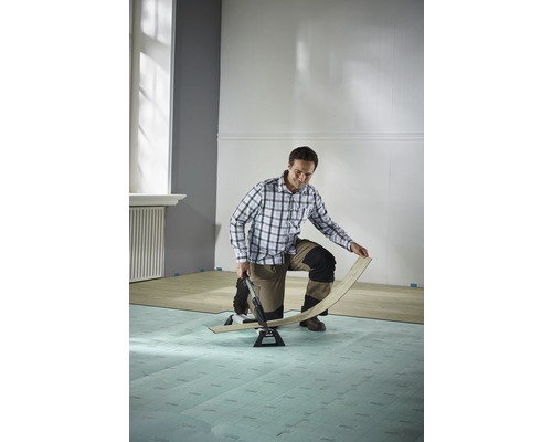 Man legt laminaat met laminaatsnijder in een kamer.