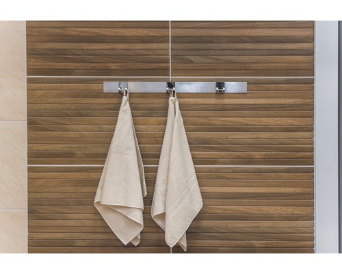 Badkamer aanzicht met handdoeken aan een handdoekenrek voor een muur met houten tegels