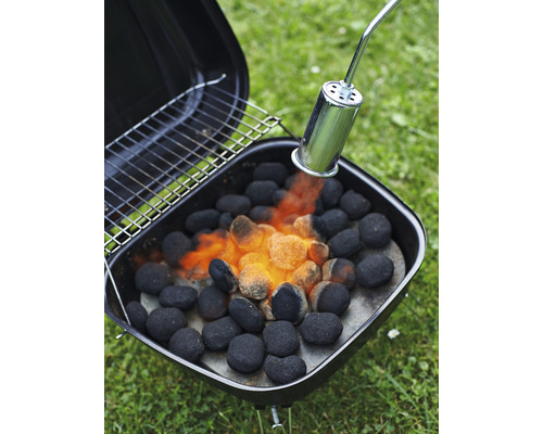 Barbecue met houtskoolstarter die houtskool aansteekt