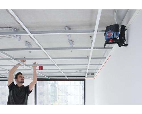 Man monteert plafondconstructie met lijnlaser voor uitlijning