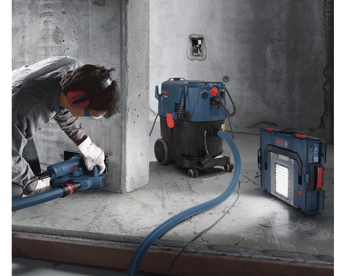 Toepassingsvoorbeeld met sleuvenzaag, industriële stofzuiger en draadloze bouwlamp op een bouwplaats