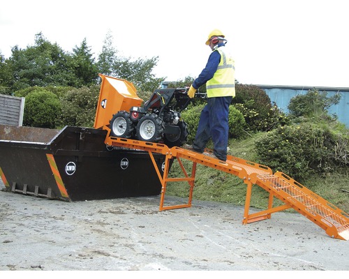 Een persoon bedient een minidumper, die via een hellingbaan in een container wordt geleegd.