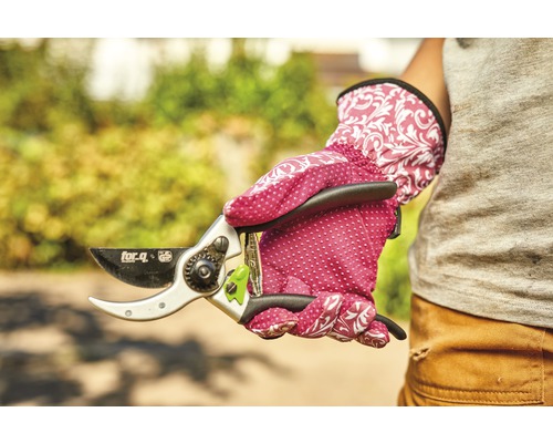 Een hand in tuinhandschoenen houdt een snoeischaar van het merk for_q vast.
