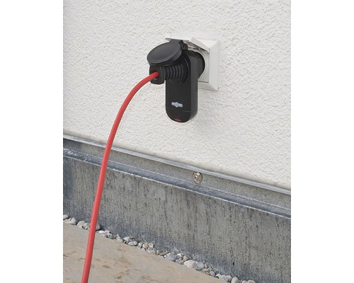 Elektrische autolader met rode kabel in een stopcontact aan de wand