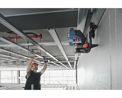 Ambachtsman gebruikt een lijnlaser voor plafondwerkzaamheden binnenshuis.