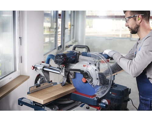 Man bedient een Bosch verstekzaag voor het zagen van een stuk hout.