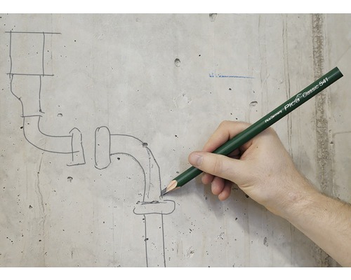 Een persoon tekent met een Pica Classic 541 stift een pijpschets op een betonnen muur.