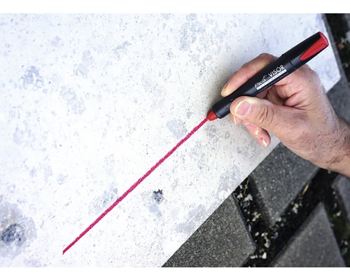 Hand tekent lijn met Pica Visor permanente marker op steen