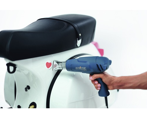 Heteluchtpistool bij het aanbrengen van een sticker op een scooter