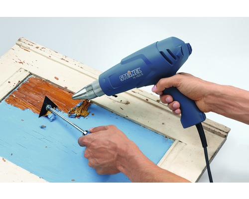 Persoon verwijdert met heteluchtpistool en plamuurmes verfresten van een deur