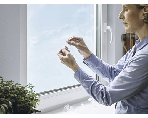 Vrouw verwijdert beschermfolie van vensterglas