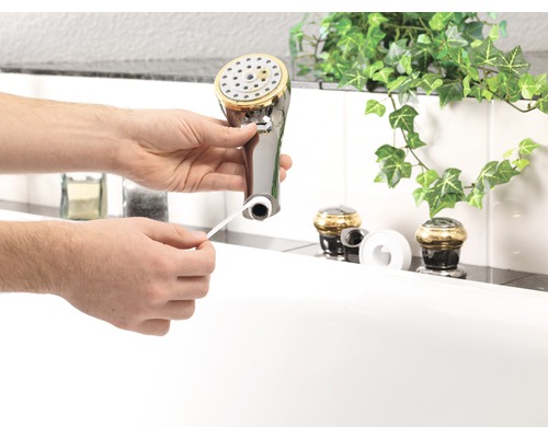 Een man bevestigt afdichtingstape aan een douchekop.