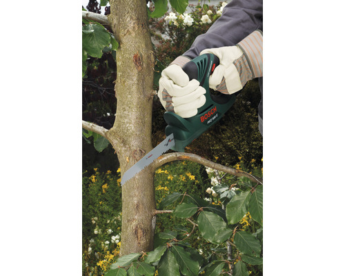 Persoon snoeit boomtak met een takkenzaag