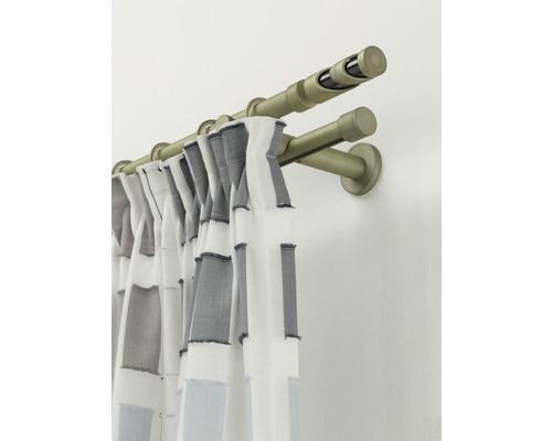 Dubbele gordijnroede met gordijn aan de muur