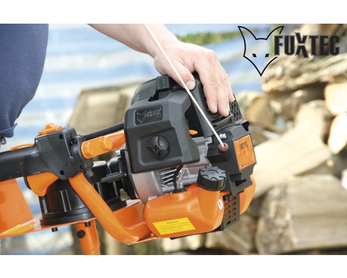 Fuxtec grondboor met bedienende hand en Fuxtec logo