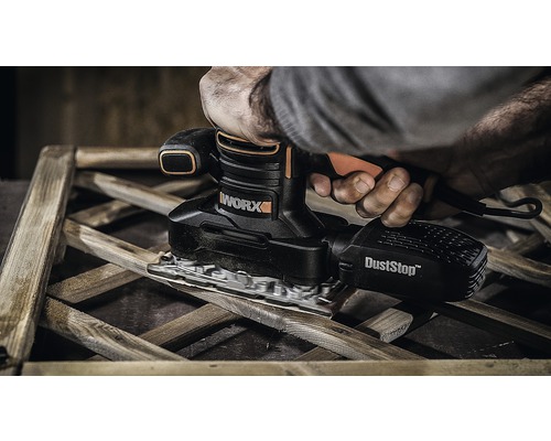 Persoon schuurt hout met een WORX vlakschuurmachine met stofafzuiging