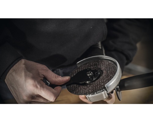 Persoon monteert een doorslijpschijf op een haakse slijper.