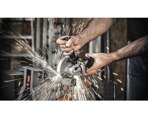 Een persoon snijdt metaal met een haakse slijper, waarbij vonken ontstaan.