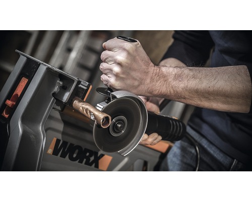 Man snijdt koperen buis met een doorslijpmachine op een werkstukhouder van het merk Worx.