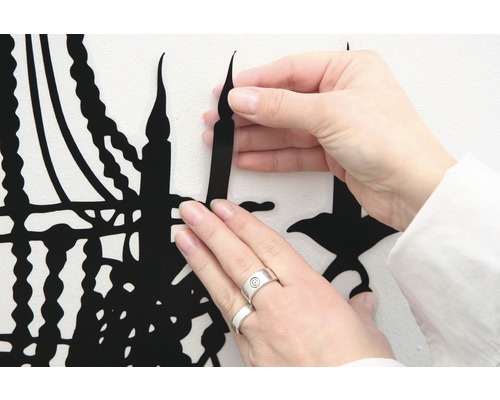 Aanbrengen van een zwarte muursticker met kandelaarmotief