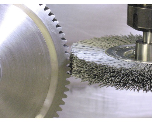 Draadborstel in gebruik op een tandwiel