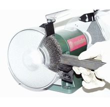 Metabo tafelslijpmachine met draadborstel bij het ontroesten van een stuk metaal