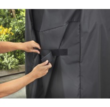 Persoon bevestigt een afdekhoes met klittenbandsluiting.