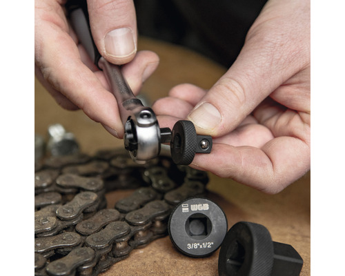 Persoon verbindt ratel met dopsleutel naast een fietsketting