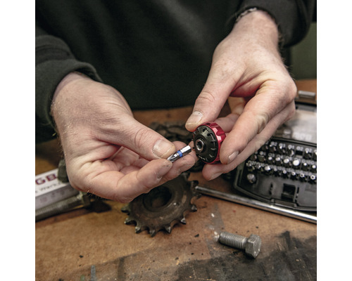 Een persoon plaatst een schroefbit in een bithouder.