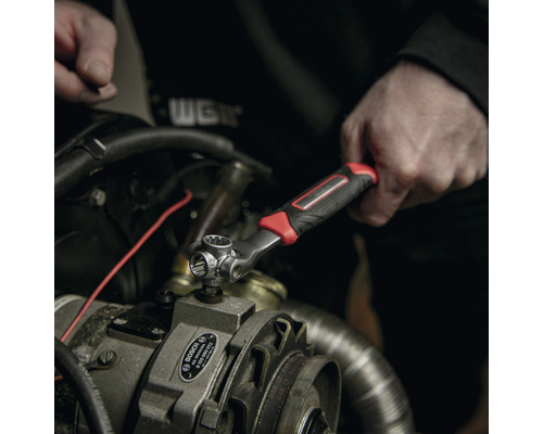 Iemand gebruikt een dopsleutel op een motor.