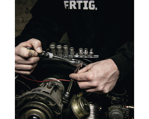Iemand gebruikt een ratelsleutel en dopsleutel voor reparaties aan een automotor.