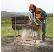 Een persoon met beschermende kleding zaagt hout met een kettingzaag op een houtzaagbok van Wolfcraft