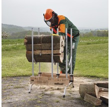 Een persoon met beschermende kleding zaagt hout op een Wolfcraft zaagbok.