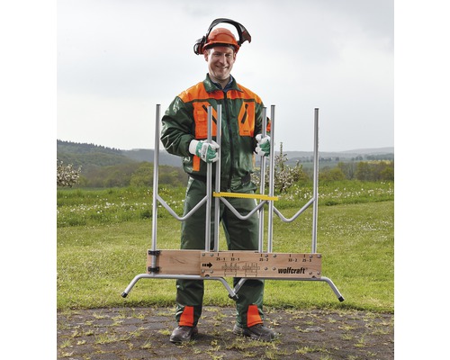 Man met beschermende kleding en Wolfcraft houtzaagbok in de buitenlucht